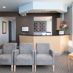 Reception desk, facing 3 chairs and large window on the right