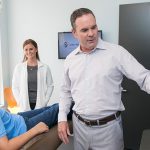 Dr Michael Stewart with young male patient and assistant in his dental office at Stewart & Arango Oral Surgery